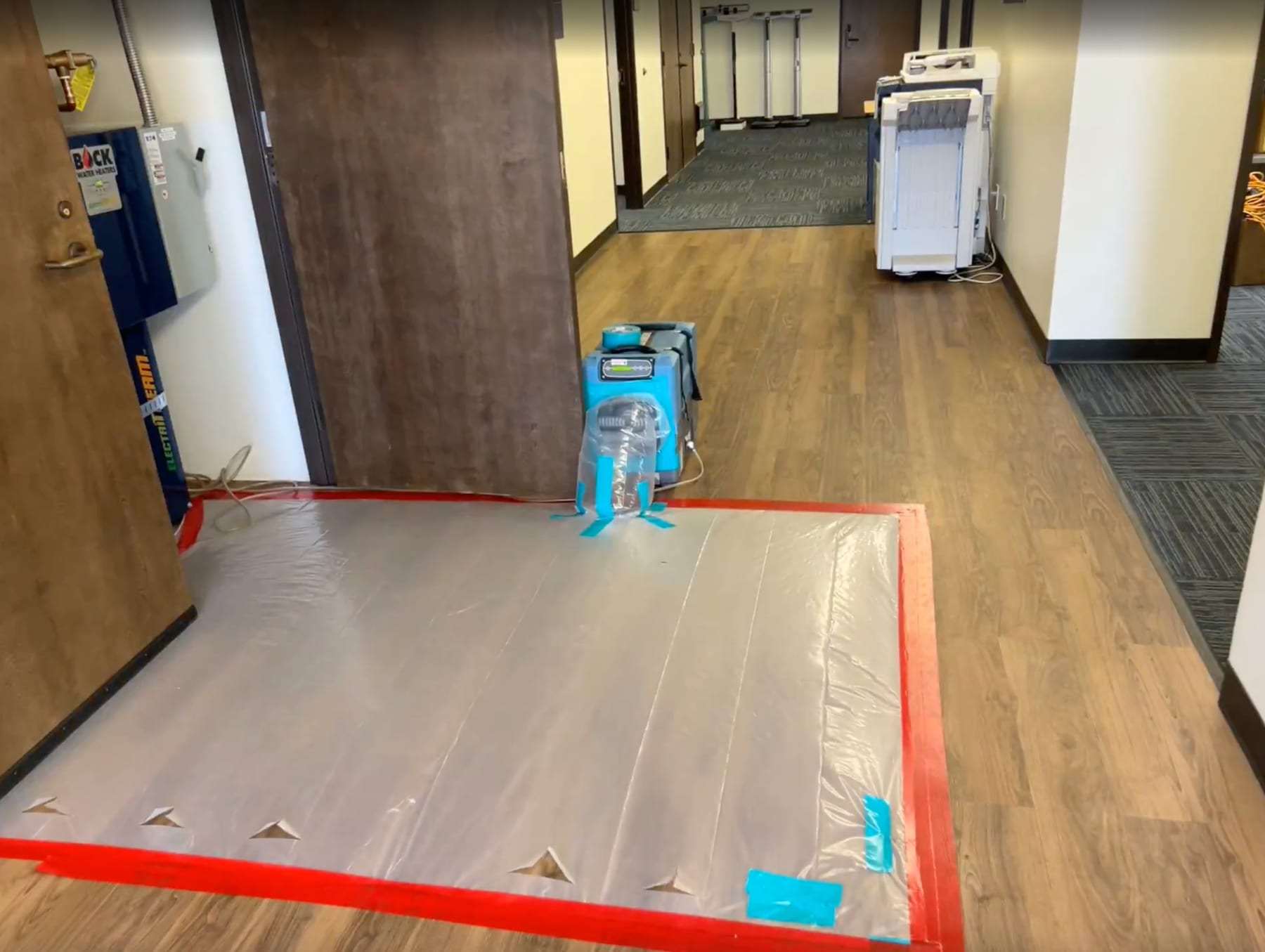 Hallway floor drying under plastic with a dehumidifier
